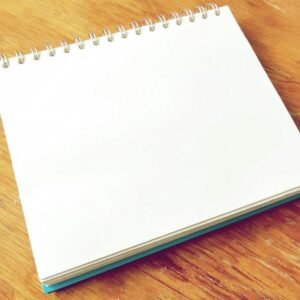 A blank spiral notebook lies open on a wooden desk, perfect for notes or sketches.